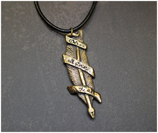 Colgante pluma "We are all stories in the end" bronce frente