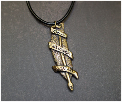 Colgante pluma "We are all stories in the end" bronce frente