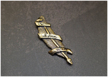 Colgante pluma "We are all stories in the end"  bronce solo lado