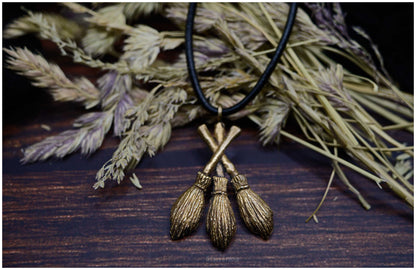 Colgante "Moiras" en forma de tres escobas de bronce frente